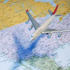 Samolot nad mapą USA. Zastanawiasz się, ile kosztuje bilet do USA w dwie strony?