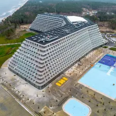 Widok z lotu ptaka na nowoczesny hotel Gołębiewski w Pobierowie z basenem i morzem w tle.