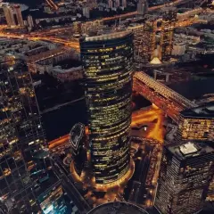 Wieżowce w Moskwie nocą, oświetlone ulice i most tworzą widok przypominający oko Moskwy.