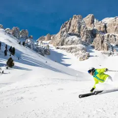Narciarz w jaskrawej kurtce szaleje na stoku w Austrii. Idealne miejsce, gdzie na narty do Austrii.