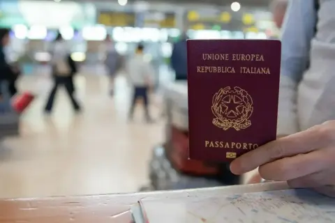 W ręce włoski paszport, gotowy do podróży. Czy na Węgry trzeba paszport? Tak, nawet w strefie Schengen.