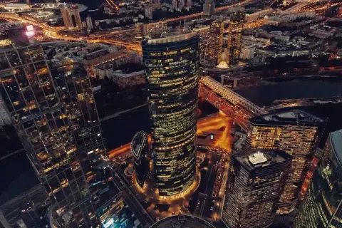 Wieżowce w Moskwie nocą, oświetlone ulice i most tworzą widok przypominający oko Moskwy.