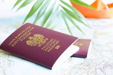 Dwa polskie paszporty leżą na mapie. Czy do Słowenii potrzebny jest paszport? Tak, jeśli podróżujesz spoza strefy Schengen.
