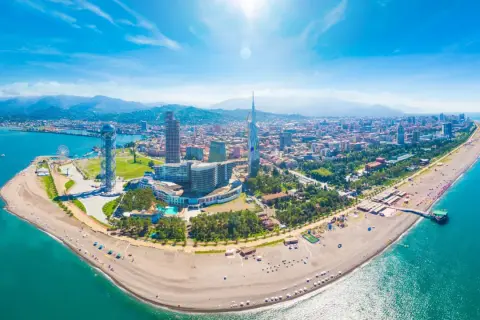 Batumi, Gruzja. Wycieczki nad Morze Czarne. Widok z lotu ptaka na plażę, nowoczesne budynki i góry w tle.