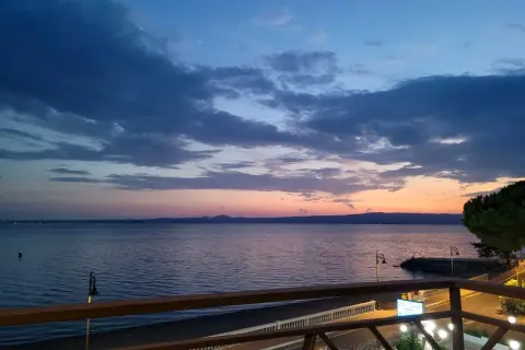 Zachód słońca nad morzem w Gaeta. Niebo w odcieniach błękitu i różu, spokojna woda, widok z tarasu.