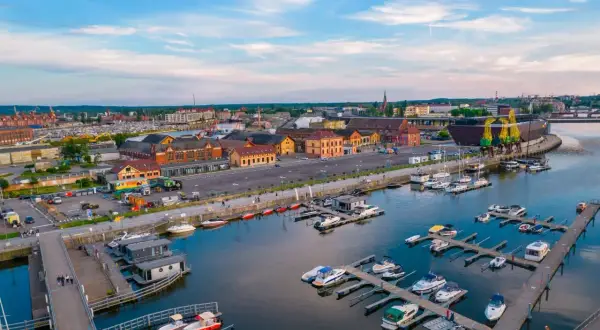 Port w Szczecinie z licznymi jachtami i łodziami, budynkami portowymi i dźwigami. Nietypowe atrakcje Szczecin czekają nad wodą!