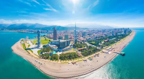Batumi, Gruzja. Wycieczki nad Morze Czarne. Widok z lotu ptaka na plażę, nowoczesne budynki i góry w tle.