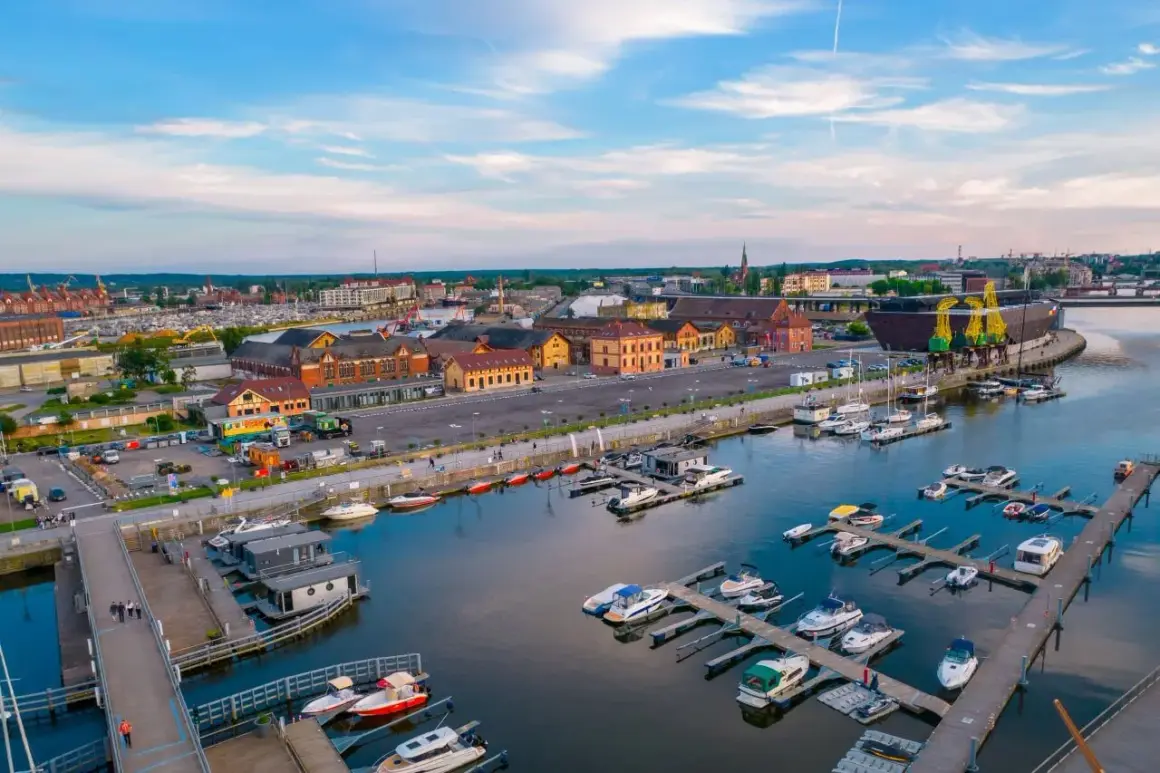 Port w Szczecinie z licznymi jachtami i łodziami, budynkami portowymi i dźwigami. Nietypowe atrakcje Szczecin czekają nad wodą!