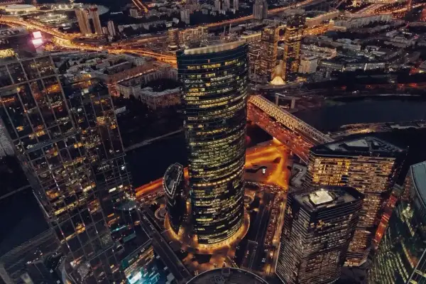 Wieżowce w Moskwie nocą, oświetlone ulice i most tworzą widok przypominający oko Moskwy.