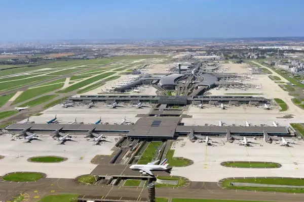 Widok z lotu ptaka na największe lotnisko w Europie, z licznymi samolotami na płycie i pasami startowymi.