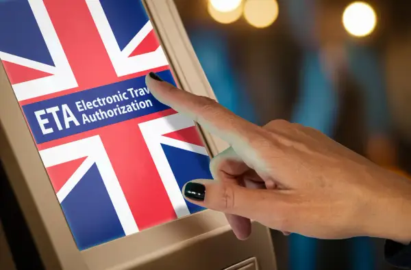 Palec dotyka ekranu z flagą Wielkiej Brytanii i napisem "ETA Electronic Travel Authorization". To krok do uzyskania wizy do Londynu.