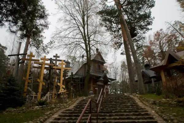 Kamienna ścieżka prowadzi do drewnianej cerkwi, otoczonej gęsto ustawionymi krzyżami. To miejsce pamięci, gdzie każdy krzyż to historia.