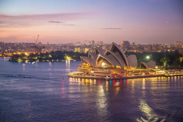 Zachód słońca nad Operą w Sydney. Marzenie o wizie do Australii staje się rzeczywistością, gdy miasto rozświetla się nocą.