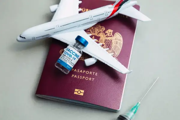 Podróż do Kenii? Pamiętaj o szczepieniach! Paszport, samolot i szczepionka COVID-19 symbolizują bezpieczne podróżowanie.